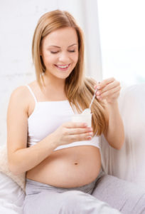 happy pregnant woman with yogurt